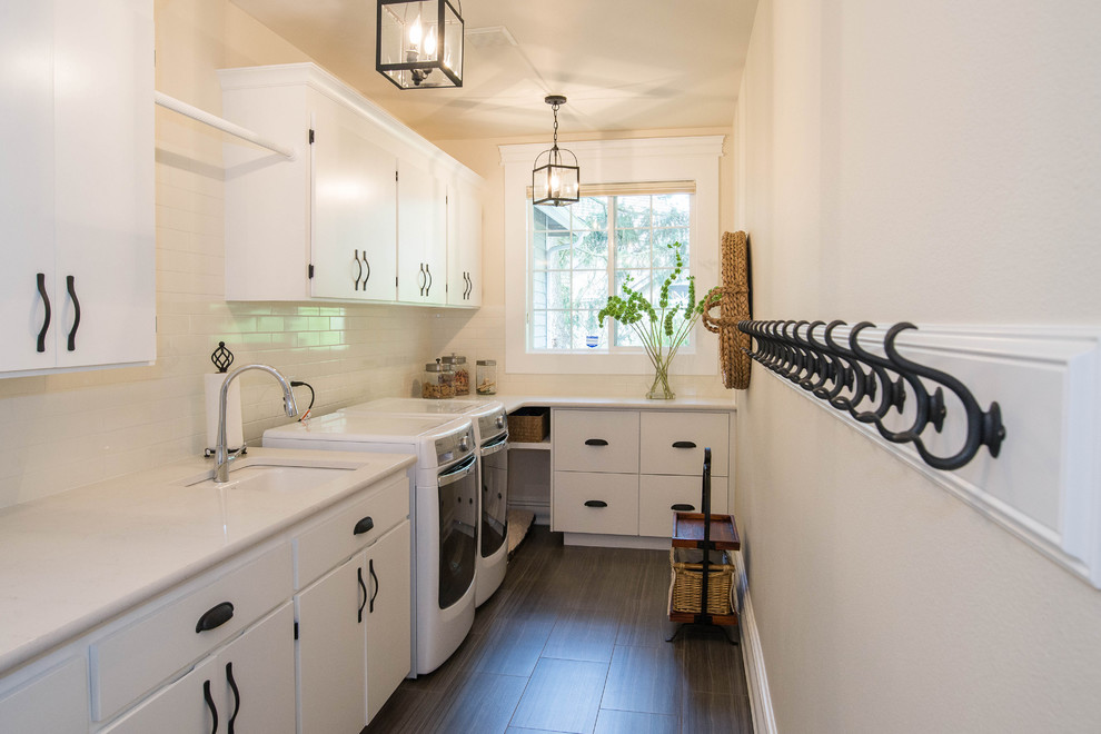 Laundry room photo in Seattle with white cabinets and a side-by-side washer/dryer