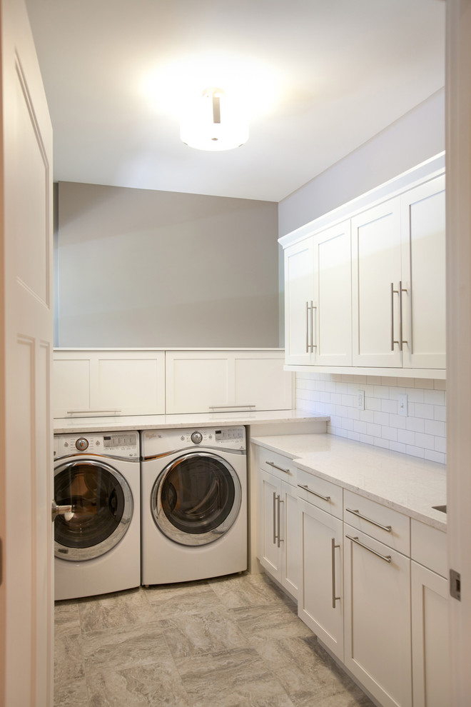 Exempel på en klassisk l-formad tvättstuga, med en undermonterad diskho, skåp i shakerstil, vita skåp, bänkskiva i kvarts, grå väggar, linoleumgolv och en tvättmaskin och torktumlare bredvid varandra