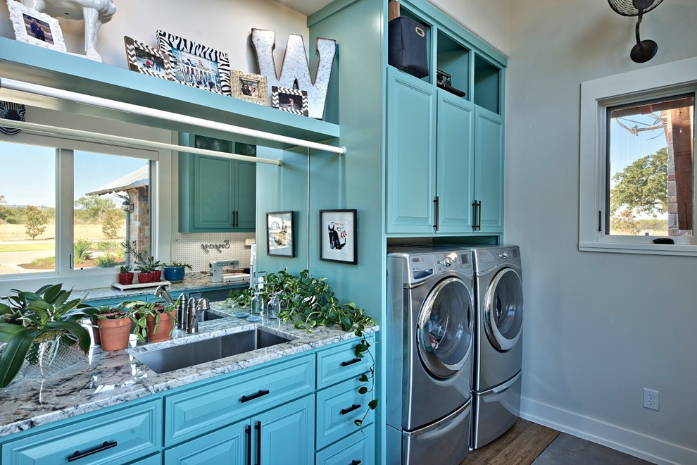 Multifunktionaler, Großer, Zweizeiliger Klassischer Hauswirtschaftsraum mit Unterbauwaschbecken, profilierten Schrankfronten, blauen Schränken, Marmor-Arbeitsplatte, grauer Wandfarbe, dunklem Holzboden und Waschmaschine und Trockner nebeneinander in Austin