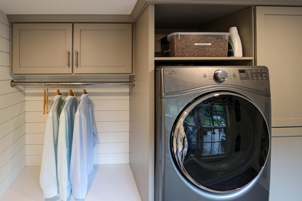 Dedicated laundry room - small transitional u-shaped dedicated laundry room idea in Cleveland with recessed-panel cabinets, gray cabinets, quartz countertops, white backsplash, shiplap backsplash, gray walls, a stacked washer/dryer and white countertops