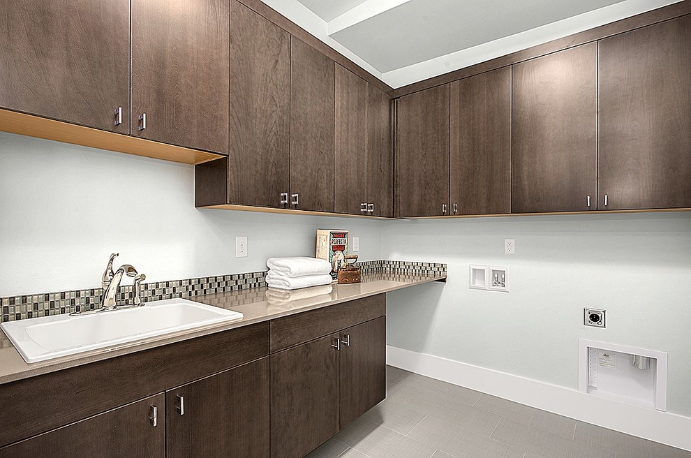 Inspiration for a large contemporary single-wall dedicated laundry room remodel in Seattle with an utility sink, shaker cabinets, medium tone wood cabinets, quartzite countertops, gray walls and a side-by-side washer/dryer