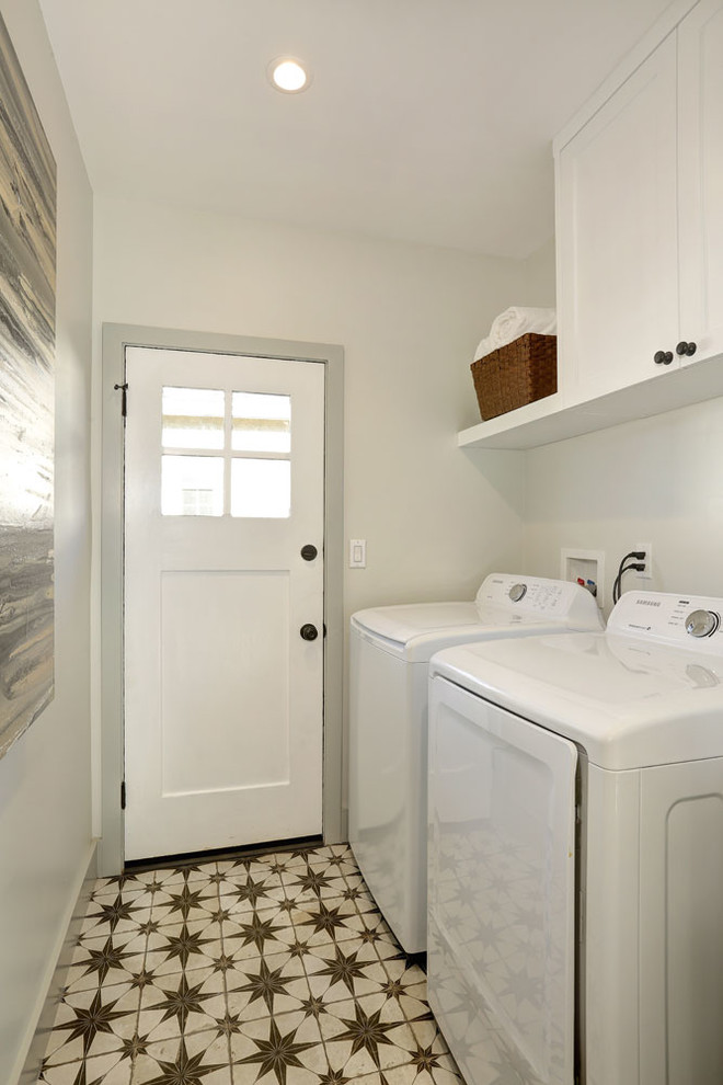Zweizeilige, Kleine Klassische Waschküche mit Schrankfronten im Shaker-Stil, weißen Schränken, grauer Wandfarbe, Porzellan-Bodenfliesen, Waschmaschine und Trockner nebeneinander und buntem Boden in Los Angeles