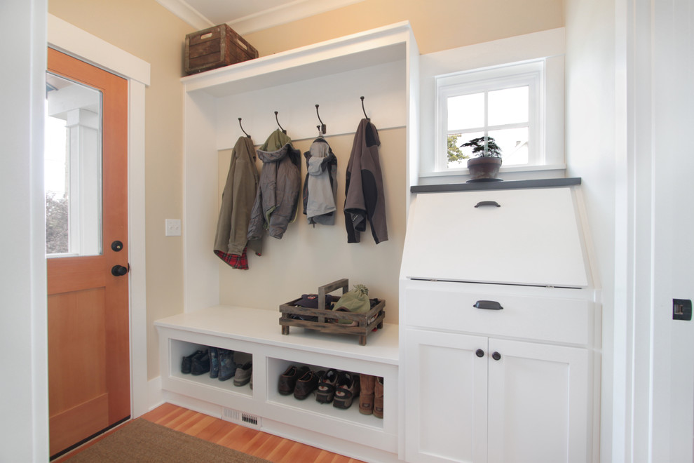 Utility room - mid-sized craftsman single-wall medium tone wood floor utility room idea in Seattle with shaker cabinets, white cabinets and beige walls
