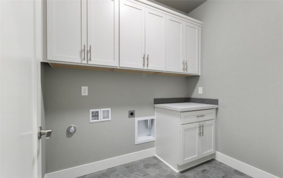 Inspiration for a mid-sized modern single-wall gray floor dedicated laundry room remodel in Portland with recessed-panel cabinets, white cabinets, gray walls and gray countertops