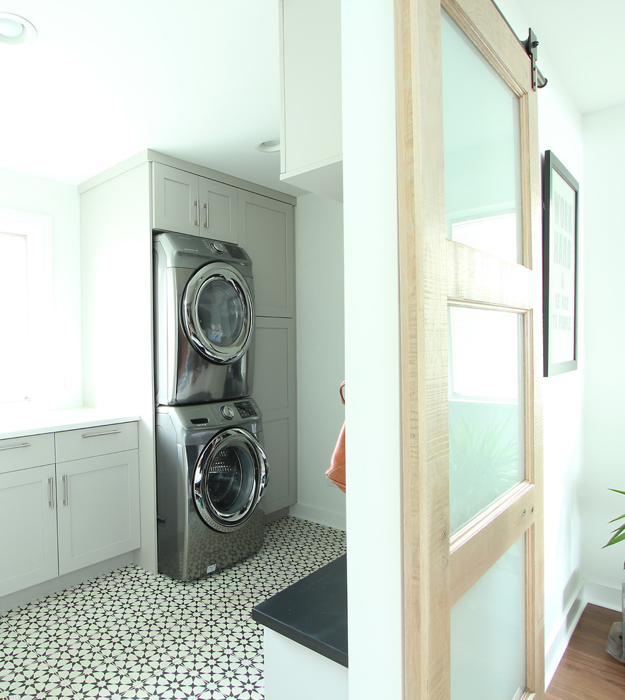 Idéer för att renovera en liten vintage linjär tvättstuga enbart för tvätt, med luckor med infälld panel, grå skåp, bänkskiva i kvarts, vita väggar, klinkergolv i porslin, en tvättpelare och flerfärgat golv