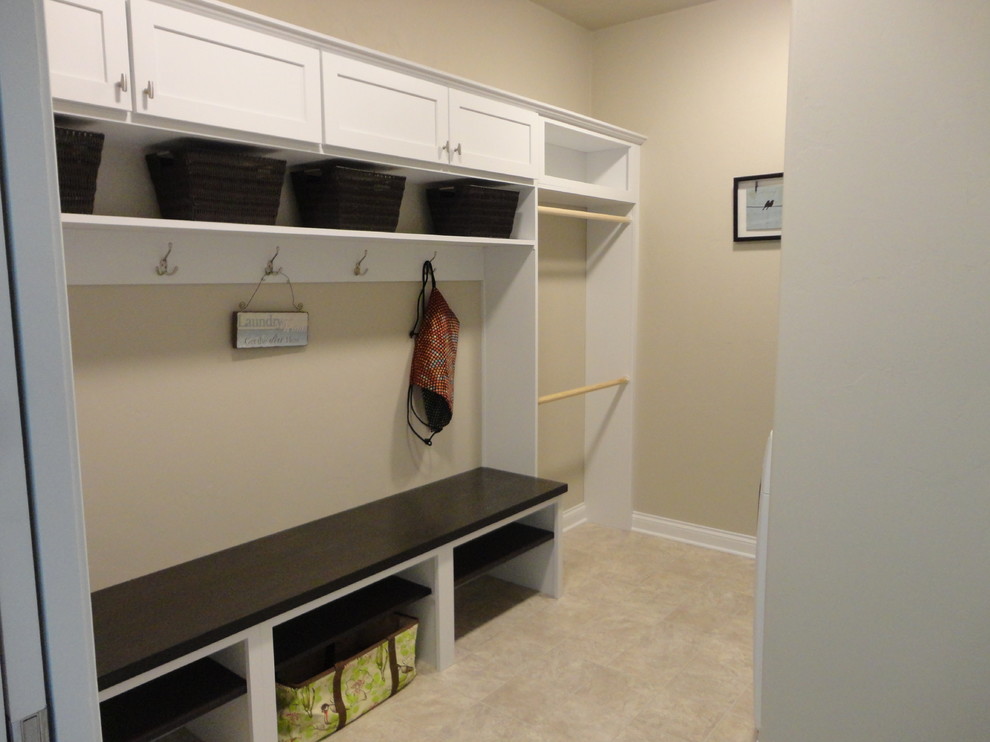 Example of a mid-sized classic galley vinyl floor utility room design in Milwaukee with recessed-panel cabinets, white cabinets, beige walls and a side-by-side washer/dryer