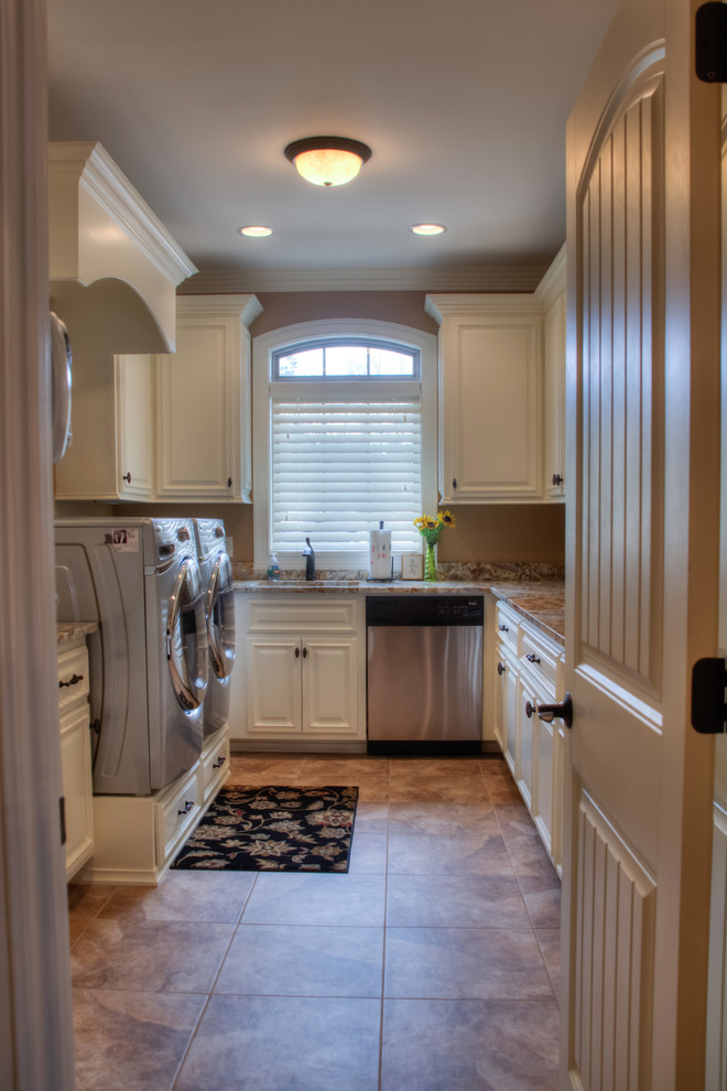 Example of a classic u-shaped porcelain tile utility room design in Other with raised-panel cabinets, white cabinets, granite countertops, a side-by-side washer/dryer, an undermount sink and brown walls