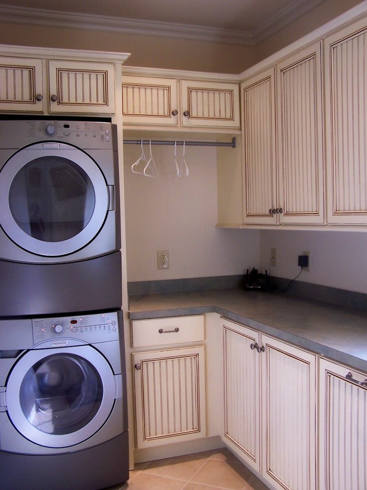 Inspiration for a large timeless laundry room remodel in Other with flat-panel cabinets, laminate countertops and a stacked washer/dryer