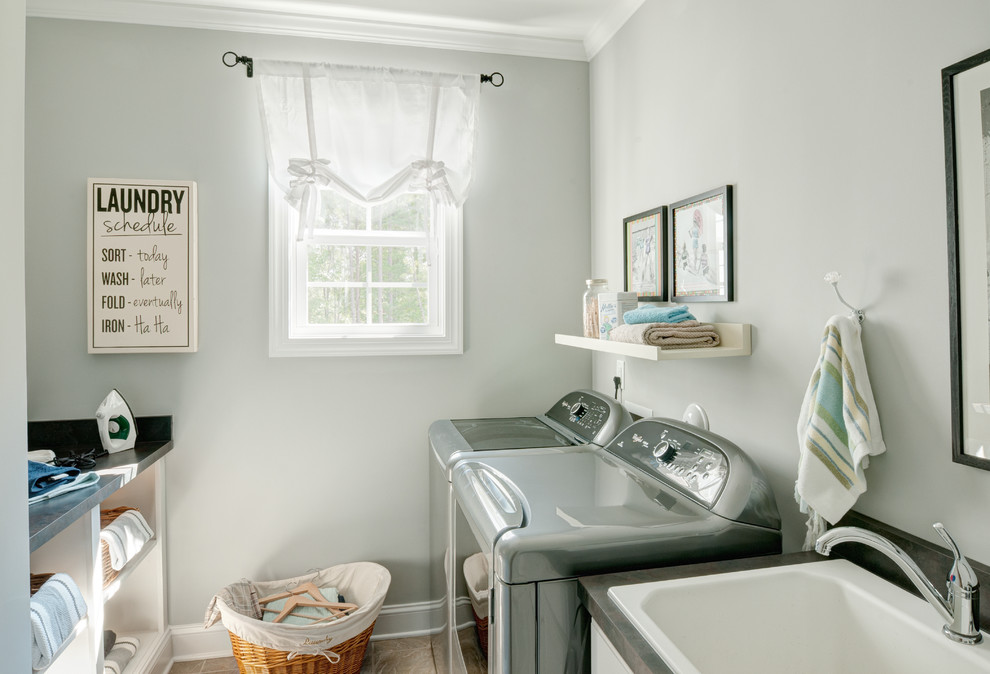 Exempel på ett mellanstort modernt grovkök, med en nedsänkt diskho, vita skåp, blå väggar, travertin golv, en tvättmaskin och torktumlare bredvid varandra, öppna hyllor och beiget golv
