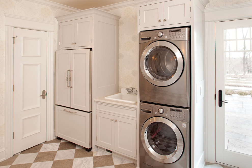 Modelo de lavadero clásico con fregadero encastrado, lavadora y secadora apiladas y suelo multicolor