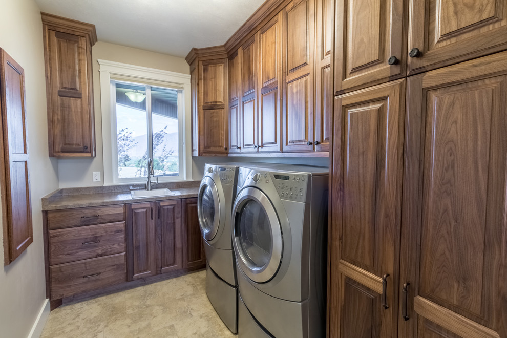 Inspiration for a mid-sized rustic galley porcelain tile utility room remodel in Salt Lake City with a drop-in sink, beaded inset cabinets, medium tone wood cabinets, granite countertops, beige walls and a side-by-side washer/dryer