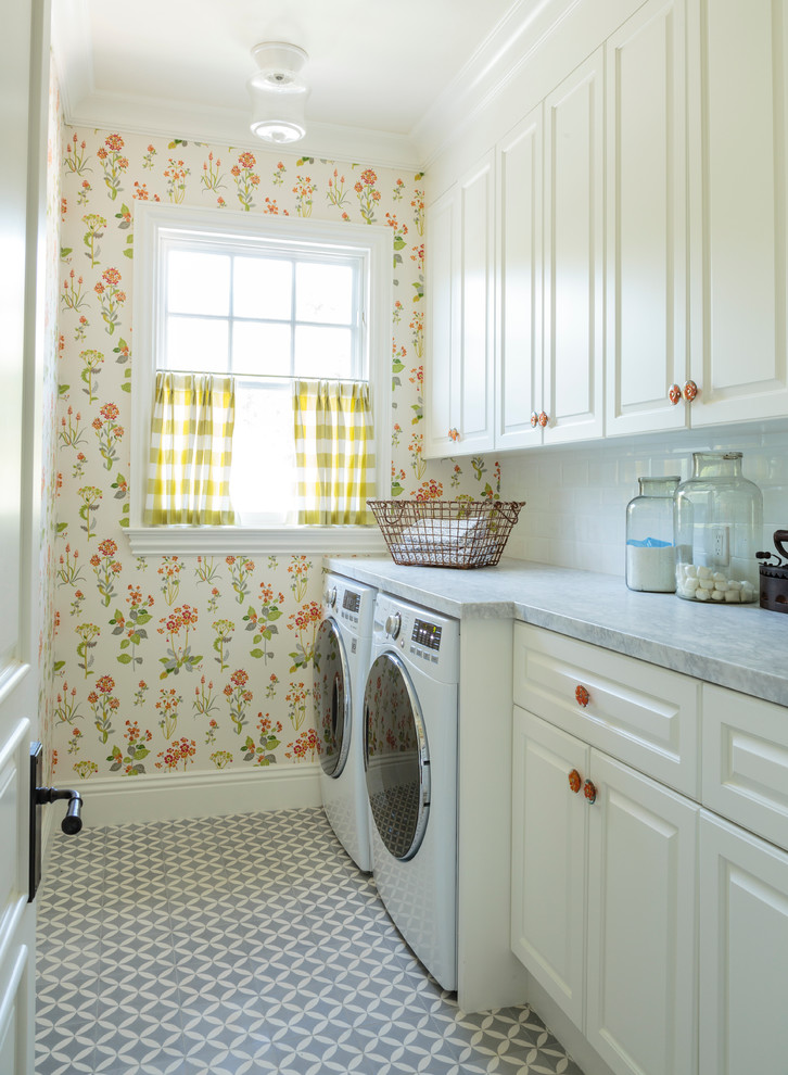 Idéer för mellanstora vintage linjära tvättstugor enbart för tvätt, med luckor med upphöjd panel, vita skåp, marmorbänkskiva, betonggolv, en tvättmaskin och torktumlare bredvid varandra och flerfärgade väggar