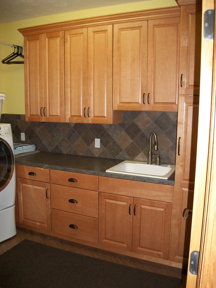 Foto di una lavanderia tradizionale con lavello da incasso, ante in stile shaker, ante in legno chiaro, top in quarzo composito, pareti gialle e lavatrice e asciugatrice affiancate