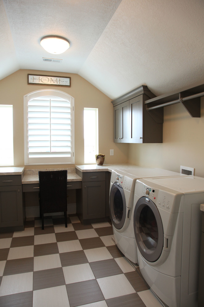 Immagine di una sala lavanderia classica di medie dimensioni con lavello sottopiano, ante in stile shaker, ante grigie, top in quarzo composito, pareti beige e lavatrice e asciugatrice affiancate