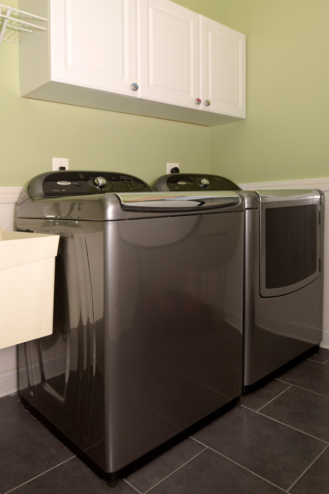 Imagen de cuarto de lavado clásico renovado de tamaño medio con pila para lavar, puertas de armario blancas, paredes verdes, suelo de baldosas de cerámica y lavadora y secadora juntas