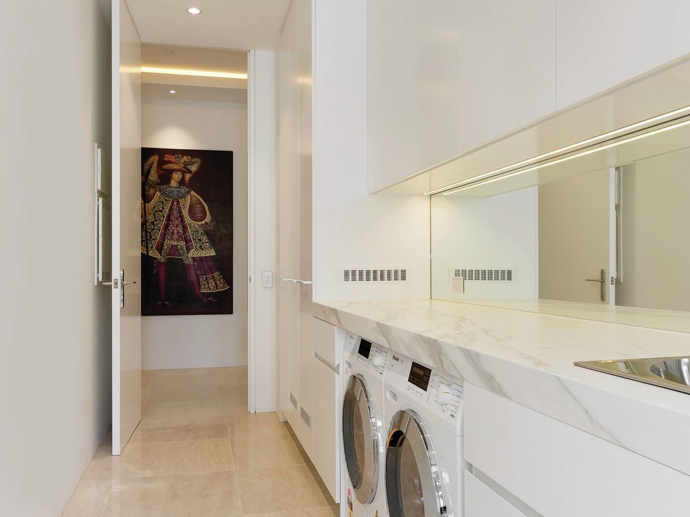 Idee per una sala lavanderia design di medie dimensioni con lavello da incasso, pareti bianche, pavimento in marmo, lavatrice e asciugatrice affiancate e pavimento beige