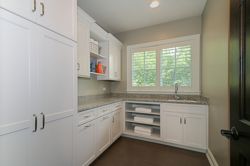 Elegant galley ceramic tile dedicated laundry room photo in Chicago with an undermount sink, recessed-panel cabinets, white cabinets, granite countertops, beige walls and a side-by-side washer/dryer