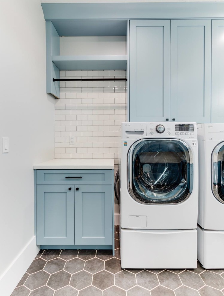 Idéer för mellanstora vintage u-formade vitt tvättstugor enbart för tvätt, med en undermonterad diskho, luckor med infälld panel, blå skåp, bänkskiva i kvarts och en tvättmaskin och torktumlare bredvid varandra