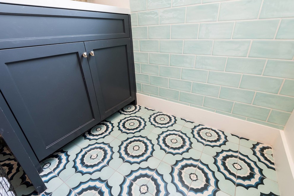 Immagine di una piccola sala lavanderia stile marinaro con ante in stile shaker, ante blu, top in quarzo composito, pareti blu, pavimento con piastrelle in ceramica, lavatrice e asciugatrice affiancate, pavimento blu e top bianco