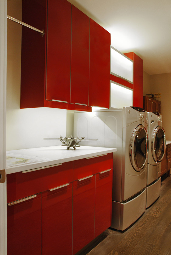 Zweizeilige, Kleine Moderne Waschküche mit flächenbündigen Schrankfronten, roten Schränken, Quarzit-Arbeitsplatte, weißer Wandfarbe und Waschmaschine und Trockner nebeneinander in Kansas City