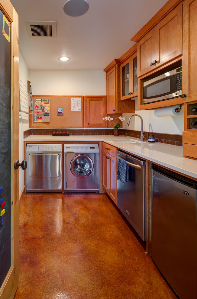 Bild på en mellanstor amerikansk tvättstuga, med beige väggar, betonggolv och brunt golv