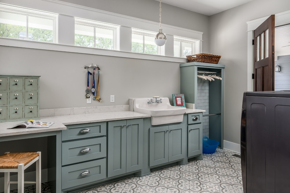 Traditional l-shaped utility room in Nashville with shaker cabinets, blue cabinets, engineered stone countertops, grey walls, medium hardwood flooring, a side by side washer and dryer and white worktops.
