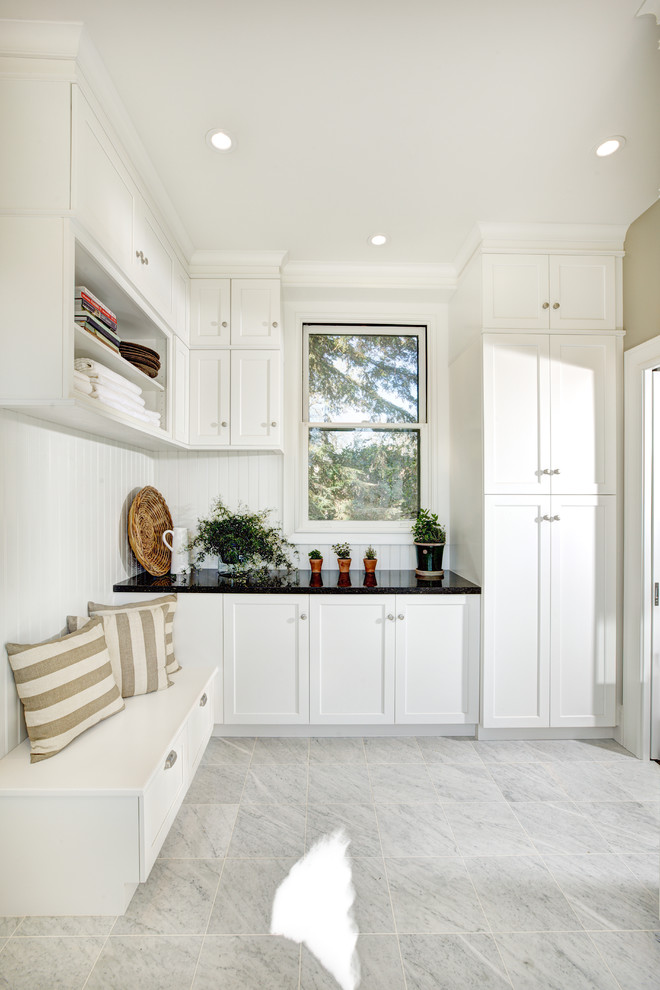 Photo of an expansive traditional l-shaped separated utility room in Sacramento with shaker cabinets, white cabinets, engineered stone countertops, white walls, marble flooring, a submerged sink and a side by side washer and dryer.