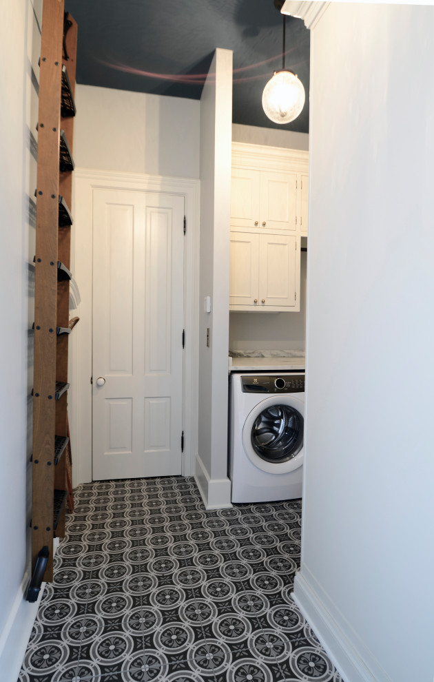 Foto di una grande lavanderia vittoriana con ante a filo, ante grigie, top in granito, pavimento in gres porcellanato, lavatrice e asciugatrice affiancate, pavimento grigio e top bianco