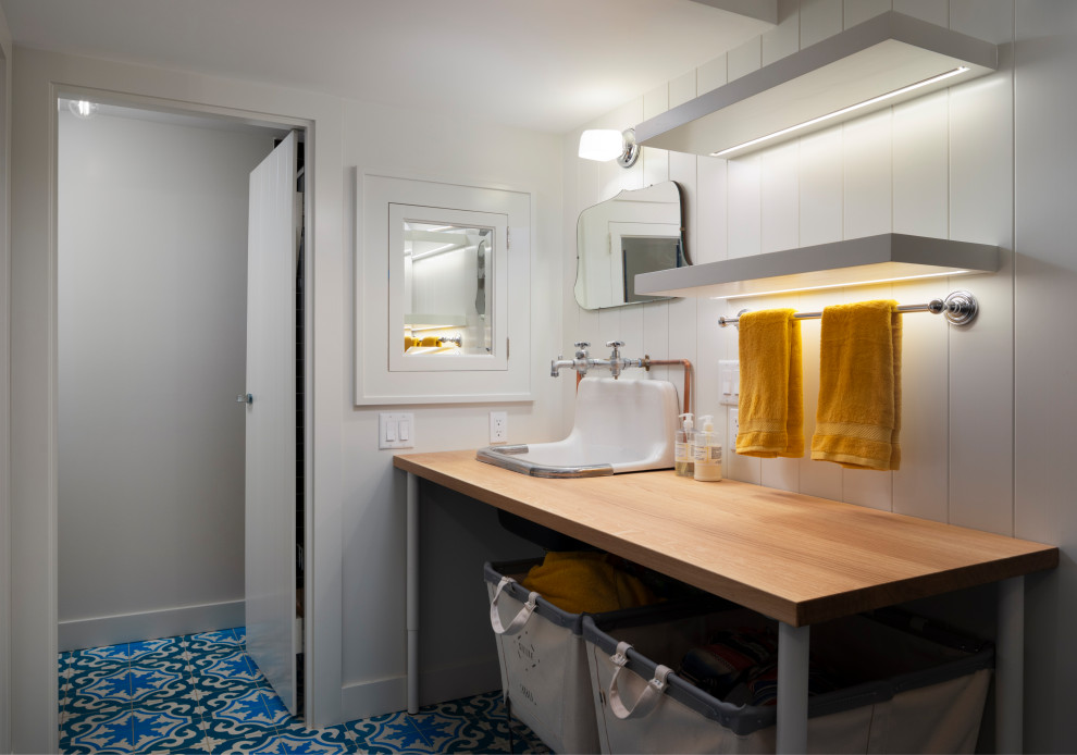 Foto di una sala lavanderia chic con lavello da incasso, top in legno, pareti bianche e pavimento multicolore