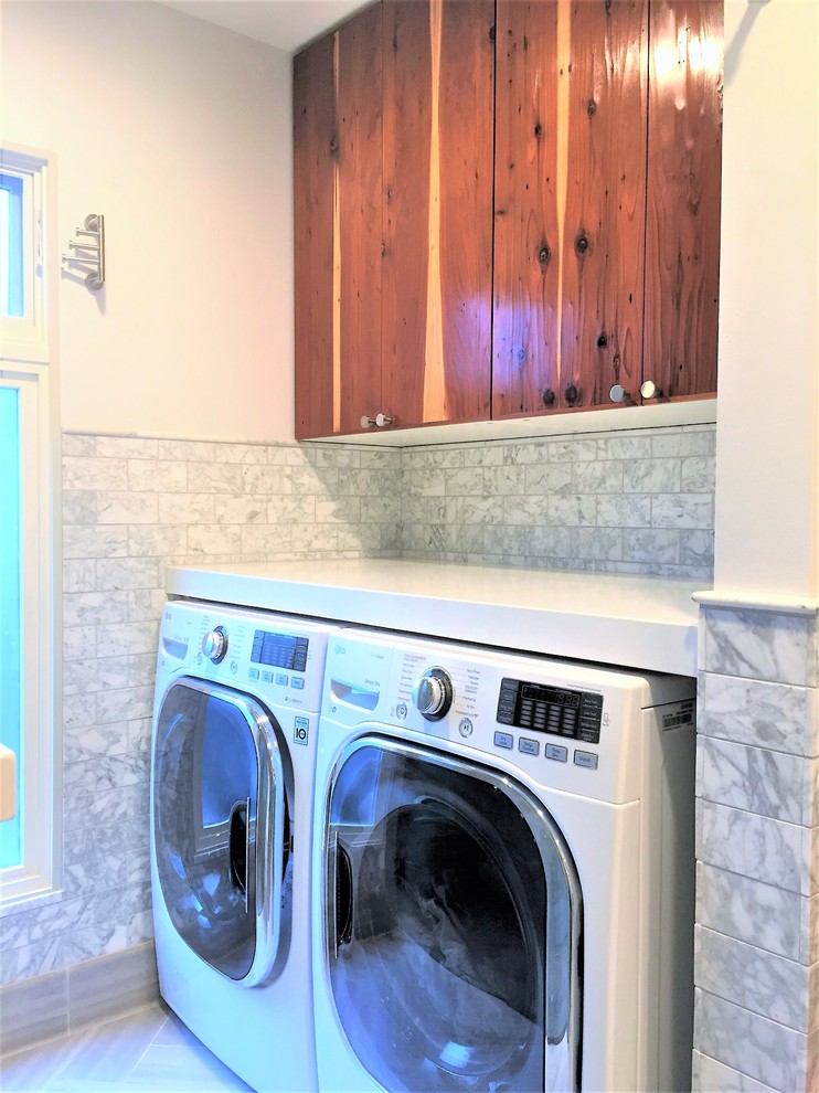 Foto di una sala lavanderia chic di medie dimensioni con ante lisce, ante in legno bruno, pareti bianche e lavatrice e asciugatrice affiancate