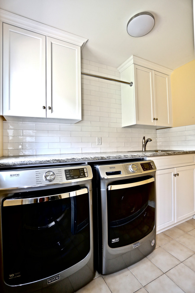 Example of a small classic single-wall utility room design in Toronto with a drop-in sink, recessed-panel cabinets, white cabinets, quartz countertops, white backsplash, porcelain backsplash, a side-by-side washer/dryer and multicolored countertops