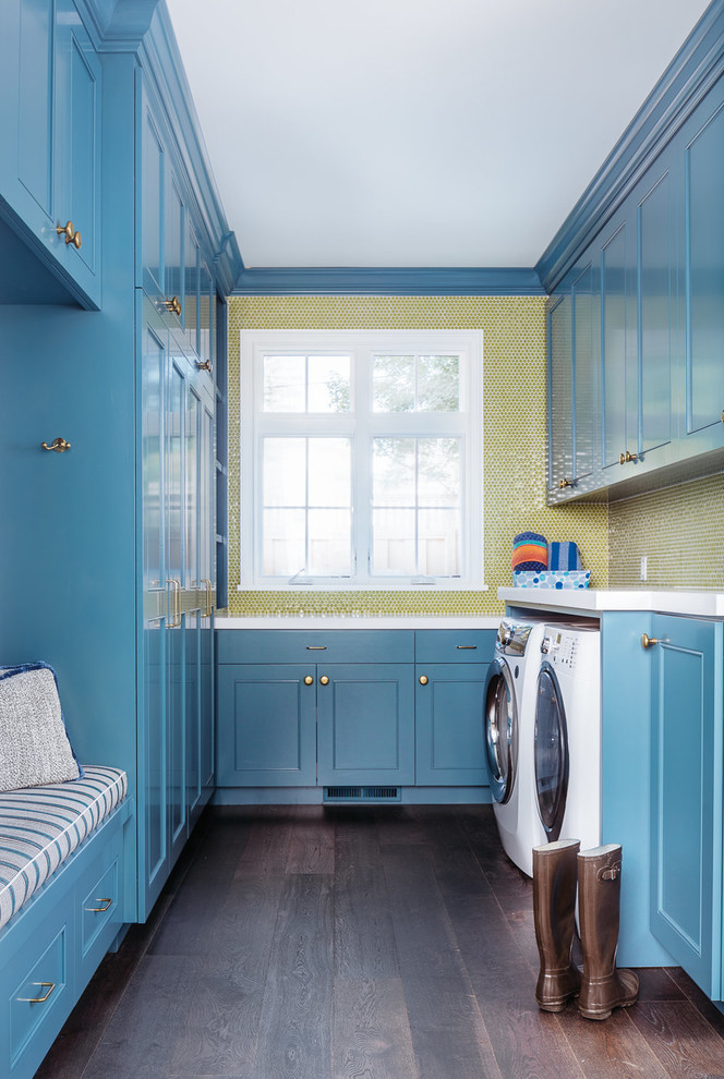 Ejemplo de lavadero multiusos y de galera tradicional renovado de tamaño medio con armarios estilo shaker, puertas de armario azules, suelo de madera oscura y lavadora y secadora juntas
