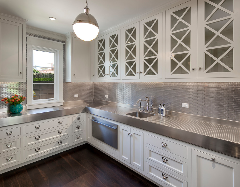 This is an example of a traditional utility room in Los Angeles with glass-front cabinets, white cabinets, stainless steel worktops, dark hardwood flooring and brown floors.