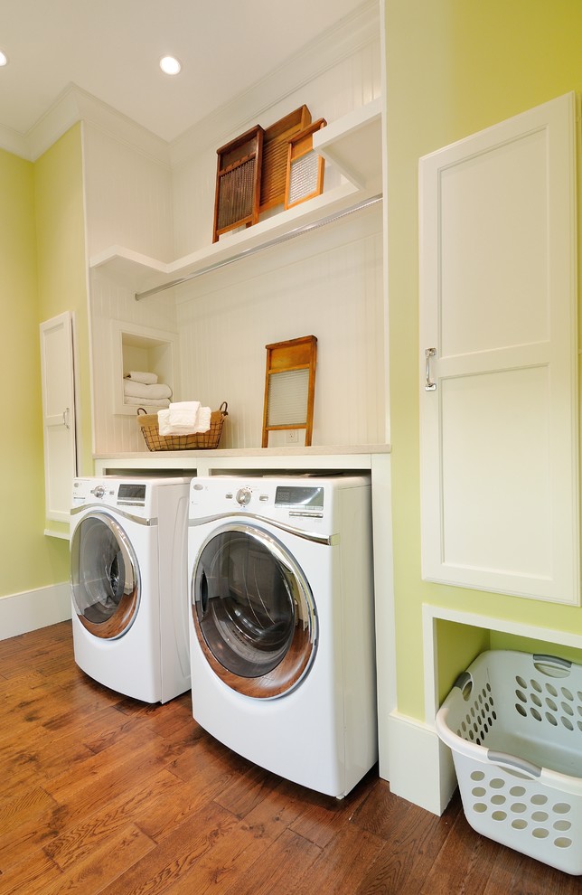 アトランタにあるお手頃価格の中くらいなトラディショナルスタイルのおしゃれなランドリールーム (左右配置の洗濯機・乾燥機、I型、オープンシェルフ、白いキャビネット、無垢フローリング、緑の壁) の写真
