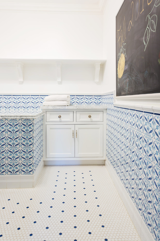 Idéer för en stor modern grå l-formad tvättstuga enbart för tvätt, med luckor med profilerade fronter, vita skåp, marmorbänkskiva, vita väggar, klinkergolv i keramik och vitt golv