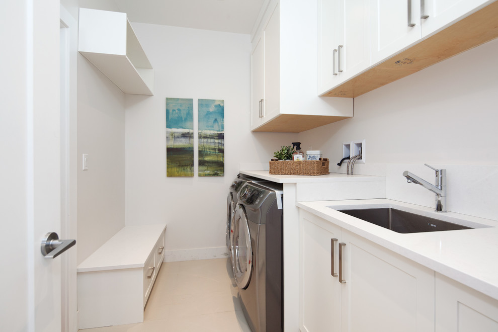 Inspiration for a large contemporary single-wall dedicated laundry room remodel in Vancouver with recessed-panel cabinets, white cabinets, quartz countertops and a side-by-side washer/dryer