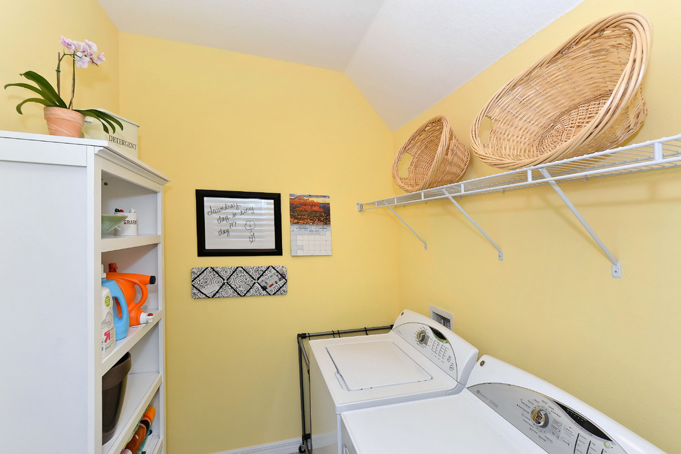 Esempio di una piccola sala lavanderia classica con nessun'anta, ante bianche, pareti gialle e lavatrice e asciugatrice affiancate