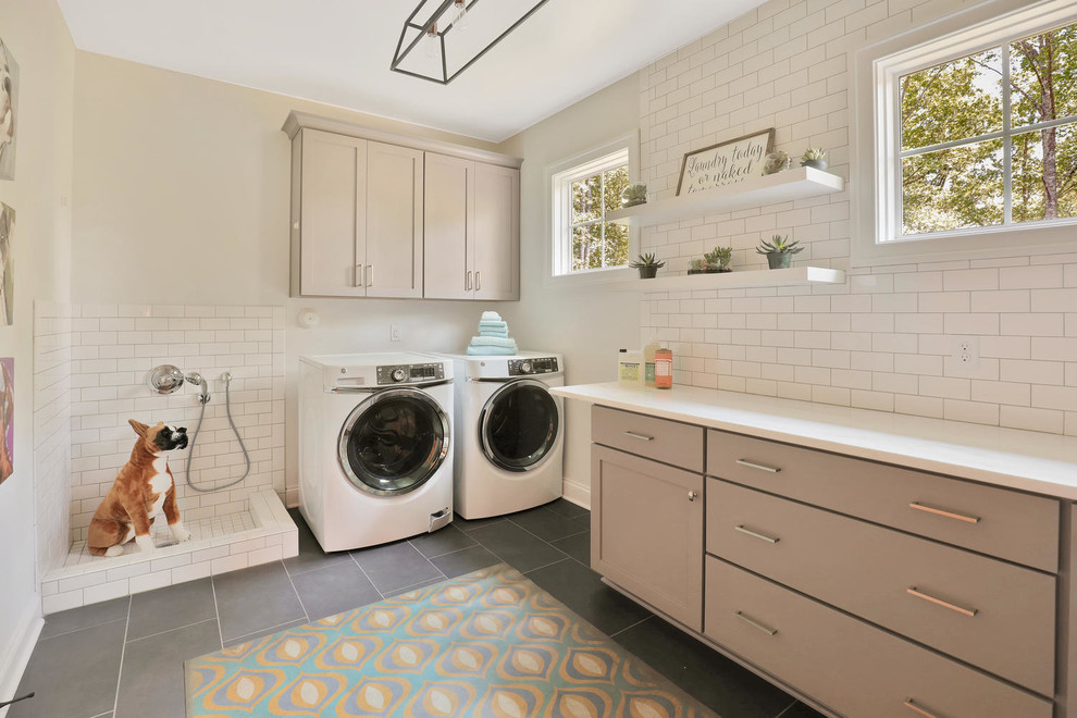 Immagine di una lavanderia multiuso tradizionale con ante in stile shaker, ante grigie, pareti bianche e lavatrice e asciugatrice affiancate