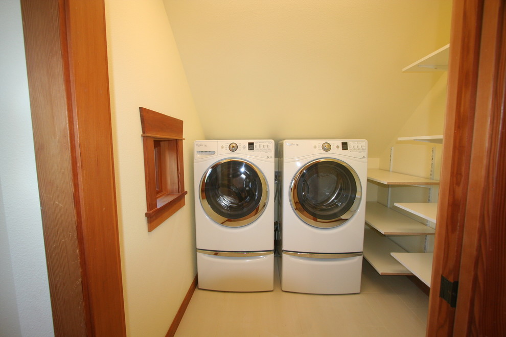 Idéer för en liten amerikansk linjär tvättstuga enbart för tvätt, med öppna hyllor, vita skåp, vita väggar, vinylgolv och en tvättmaskin och torktumlare bredvid varandra