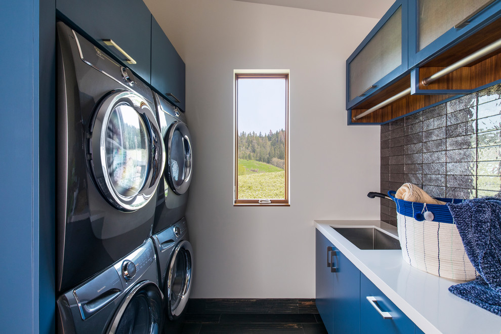 Moderne Waschküche mit Unterbauwaschbecken, flächenbündigen Schrankfronten, blauen Schränken, weißer Wandfarbe und weißer Arbeitsplatte in San Luis Obispo