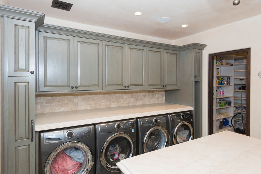Example of a large tuscan u-shaped ceramic tile and multicolored floor utility room design in New York with raised-panel cabinets, gray cabinets, granite countertops, beige walls, a side-by-side washer/dryer and beige countertops