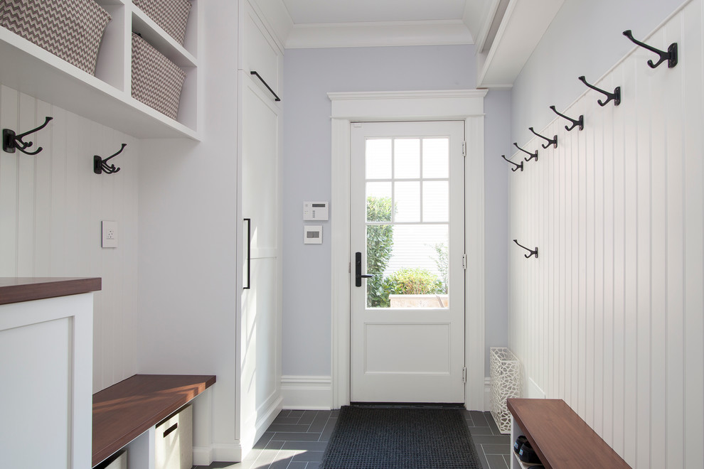 На фото: параллельная универсальная комната среднего размера в стиле неоклассика (современная классика) с фасадами в стиле шейкер, белыми фасадами, деревянной столешницей, серыми стенами и полом из керамогранита с
