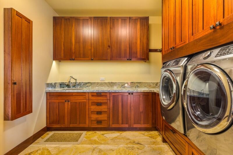 Idéer för en stor amerikansk u-formad tvättstuga enbart för tvätt, med en undermonterad diskho, skåp i shakerstil, skåp i mellenmörkt trä, granitbänkskiva, gula väggar och travertin golv