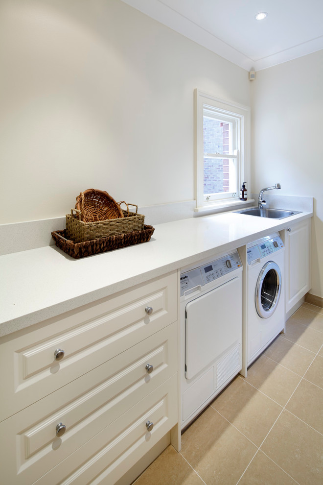 Utility room - mid-sized traditional single-wall utility room idea in Sydney with an undermount sink, white cabinets, white walls and a side-by-side washer/dryer