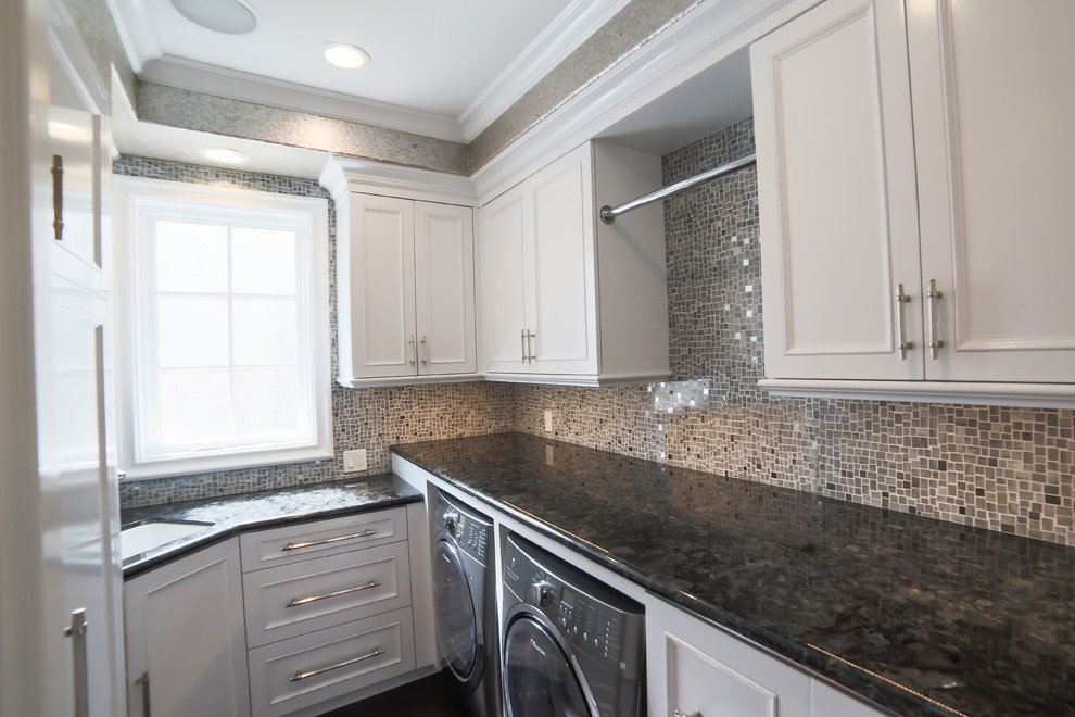 Mittelgroße Waschküche in L-Form mit Schrankfronten im Shaker-Stil, weißen Schränken, Granit-Arbeitsplatte, beiger Wandfarbe, dunklem Holzboden und braunem Boden in Orange County