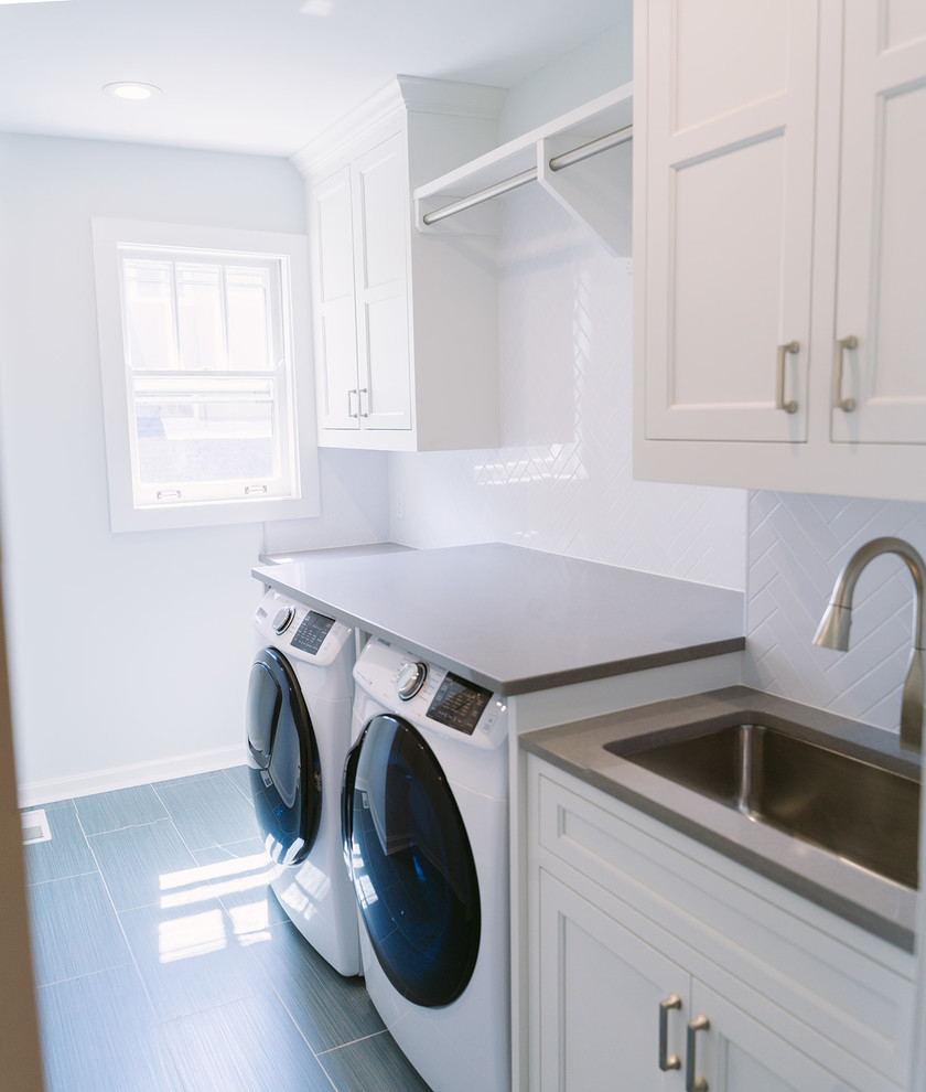 Idéer för mellanstora vintage parallella grått tvättstugor enbart för tvätt och med garderob, med en enkel diskho, vita skåp, bänkskiva i kvarts, vita väggar, klinkergolv i keramik, grått golv och luckor med infälld panel