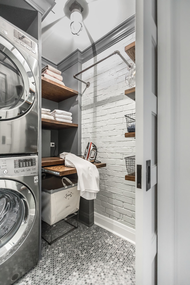 Photo of a small industrial utility room in Chicago with wood worktops, grey walls, porcelain flooring, a stacked washer and dryer, open cabinets and brown worktops.