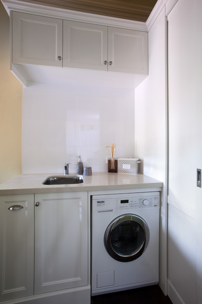 Esempio di una lavanderia classica con lavello sottopiano, top in quarzo composito, ante bianche, ante in stile shaker e top beige
