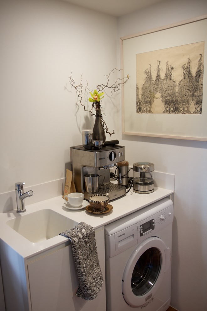 ブリスベンにある小さなコンテンポラリースタイルのおしゃれな家事室 (I型、シングルシンク、白いキャビネット、人工大理石カウンター、白い壁、濃色無垢フローリング) の写真