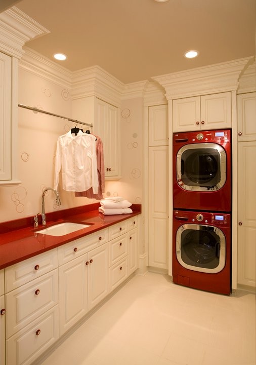 Photo of an utility room in Minneapolis with white cabinets, white walls, a stacked washer and dryer and raised-panel cabinets.